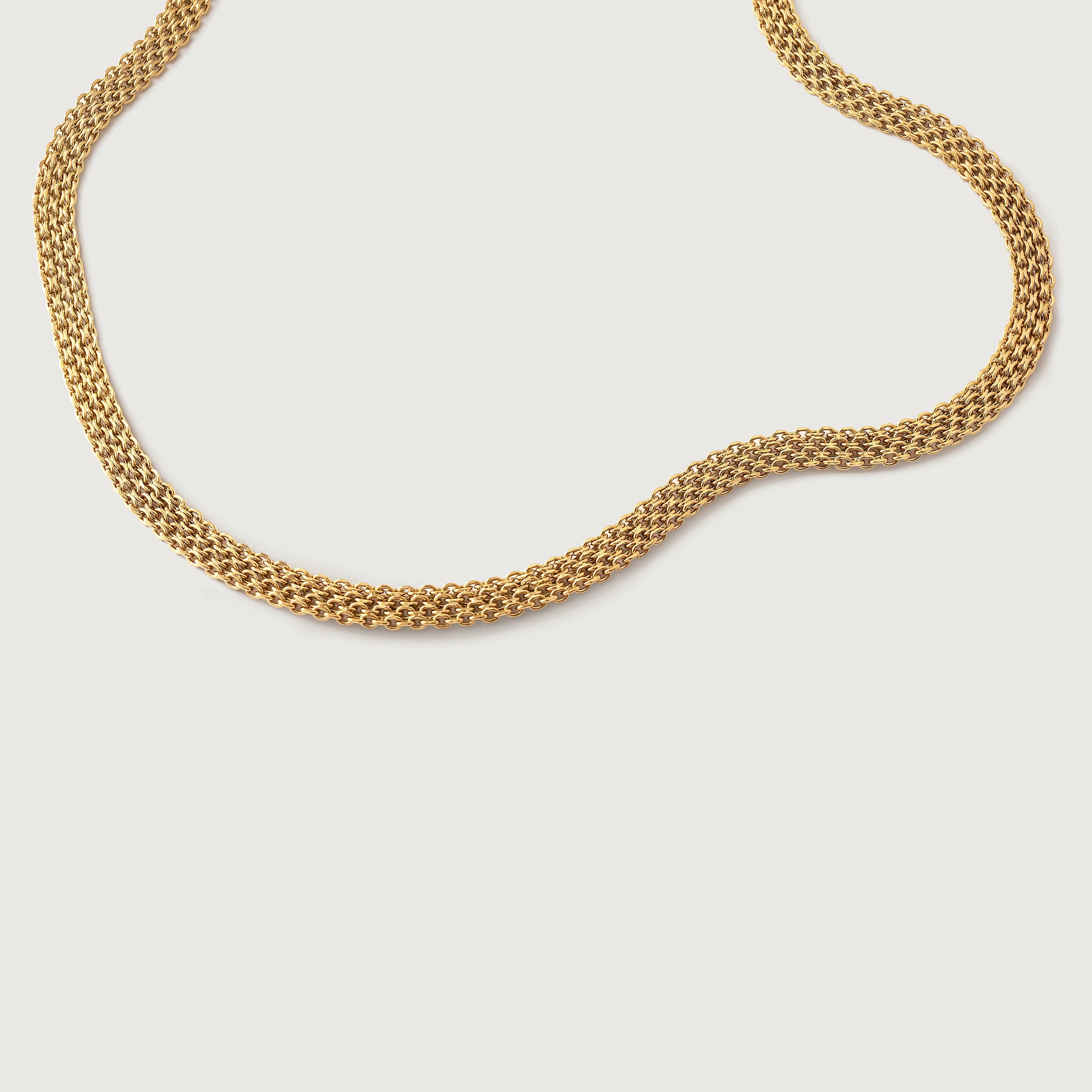 A gold-plated mesh necklace with a fluid ribbon design, displayed against a white background.