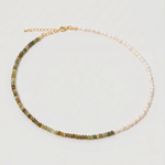 multi gemstone and pearl beaded necklace in gold, with one half strung with imitation pearl rice beads and the other half with faceted mixed quartz beads in green, sage, olive and warm brown tones, joined by a gold accent bead.