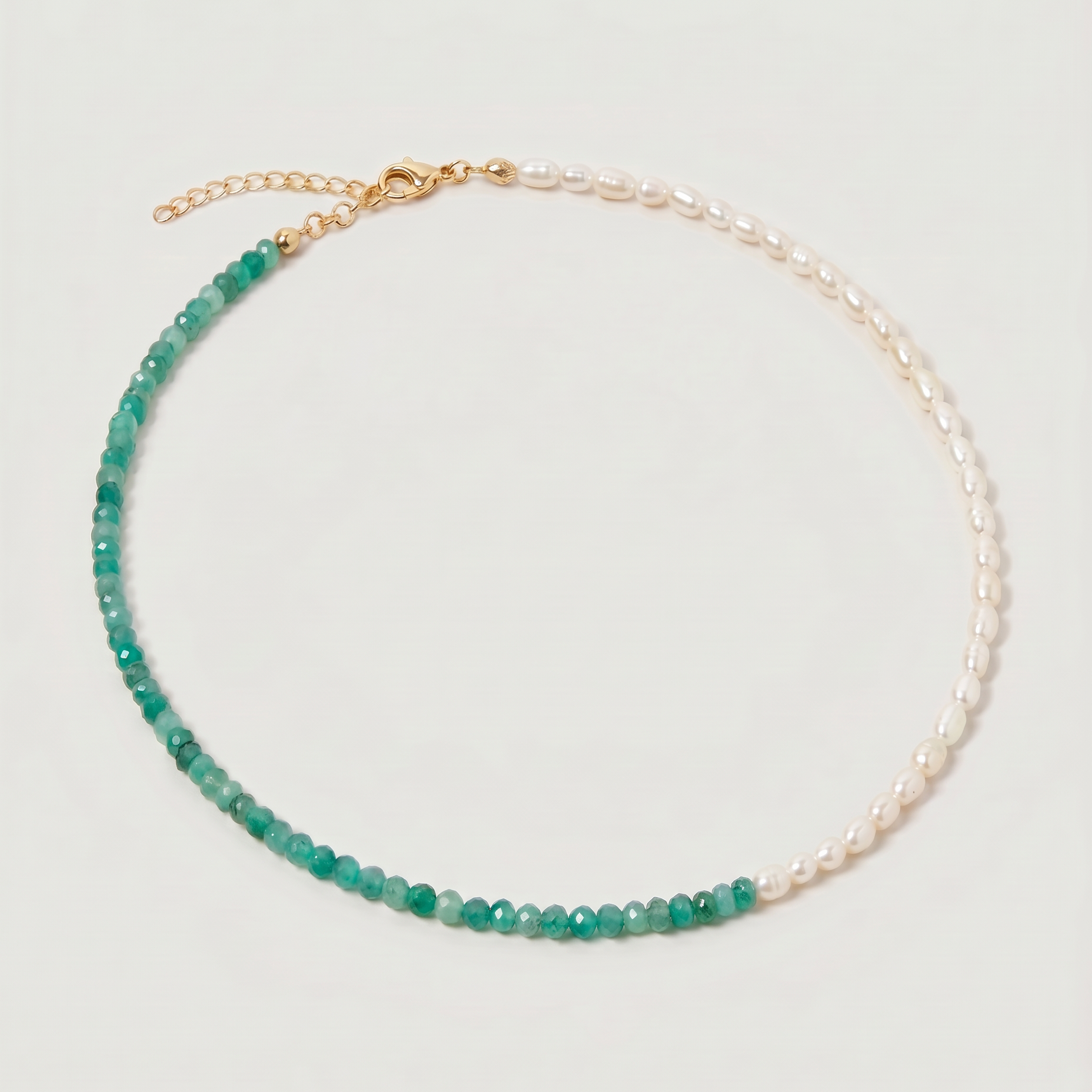 green aventurine and pearl beaded necklace in gold, with one half strung with pearls and the other half with faceted green aventurine beads in fresh green tones.