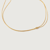 A gold-plated choker necklace with a simple infinity symbol design, featuring two loops that form a knot on one side.