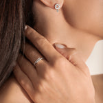 close shot of a model wearing a silver ring with an open spiral design adorned with sparkling cubic zirconia stones