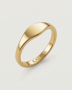 A gold signet ring with a smooth, curved surface on a white background.