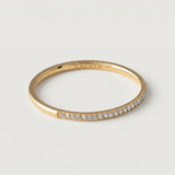 A gold-plated ring with a row of sparkling cubic zirconia stones set in a pavé effect along the band.