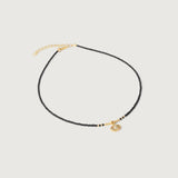 A gold-plated choker necklace with black beads and a crystal-embellished evil eye pendant, featuring an adjustable gold chain.