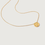 A gold-plated necklace with a round medallion pendant adorned with crystal stars on a brushed metal disc, displayed against a white background.