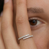 Close-up of a hand wearing a silver ring with an open spiral design adorned with sparkling cubic zirconia stones