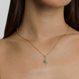 Gold necklace with a star-shaped pendant worn by a person