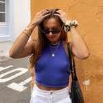Woman in blue top and white pants wearing multiple Kaleya studio jewellery products