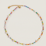 Necklace with multicolored beads and pearl-like elements on a light gray background