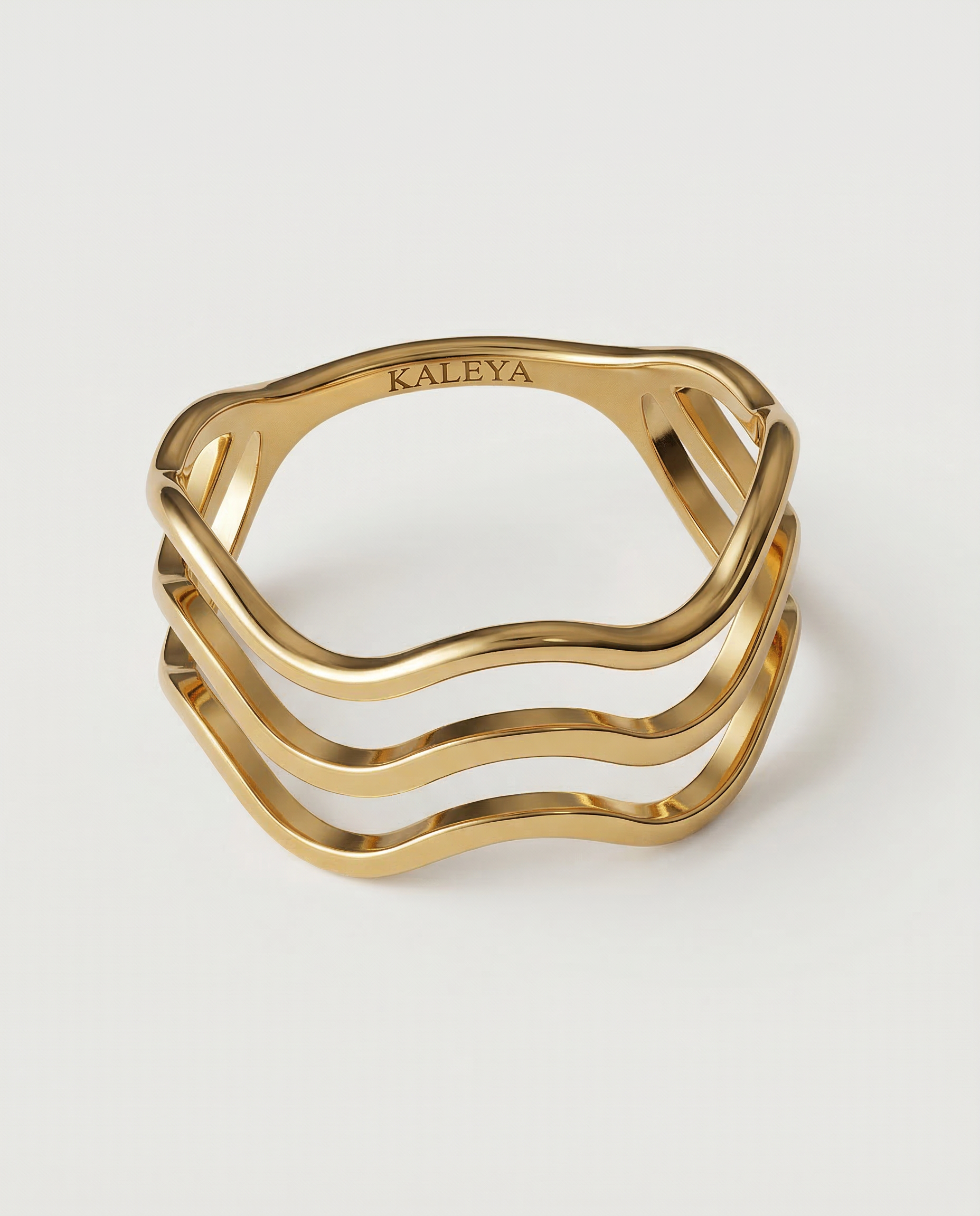 A gold-plated ring with a wave design open band, showing four curved bands that create a sense of lightness and movement.