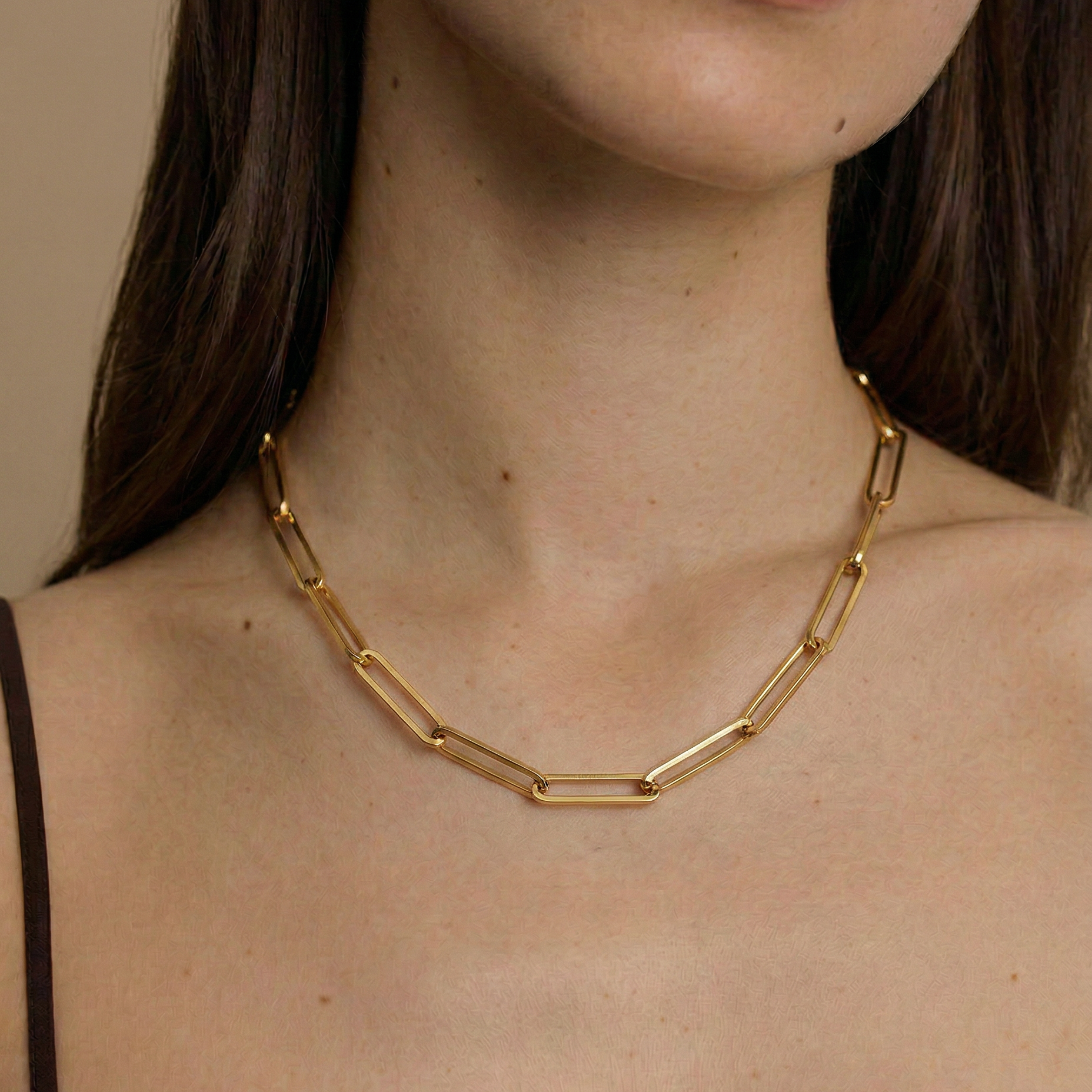 model wearing a gold paperclip chain necklace