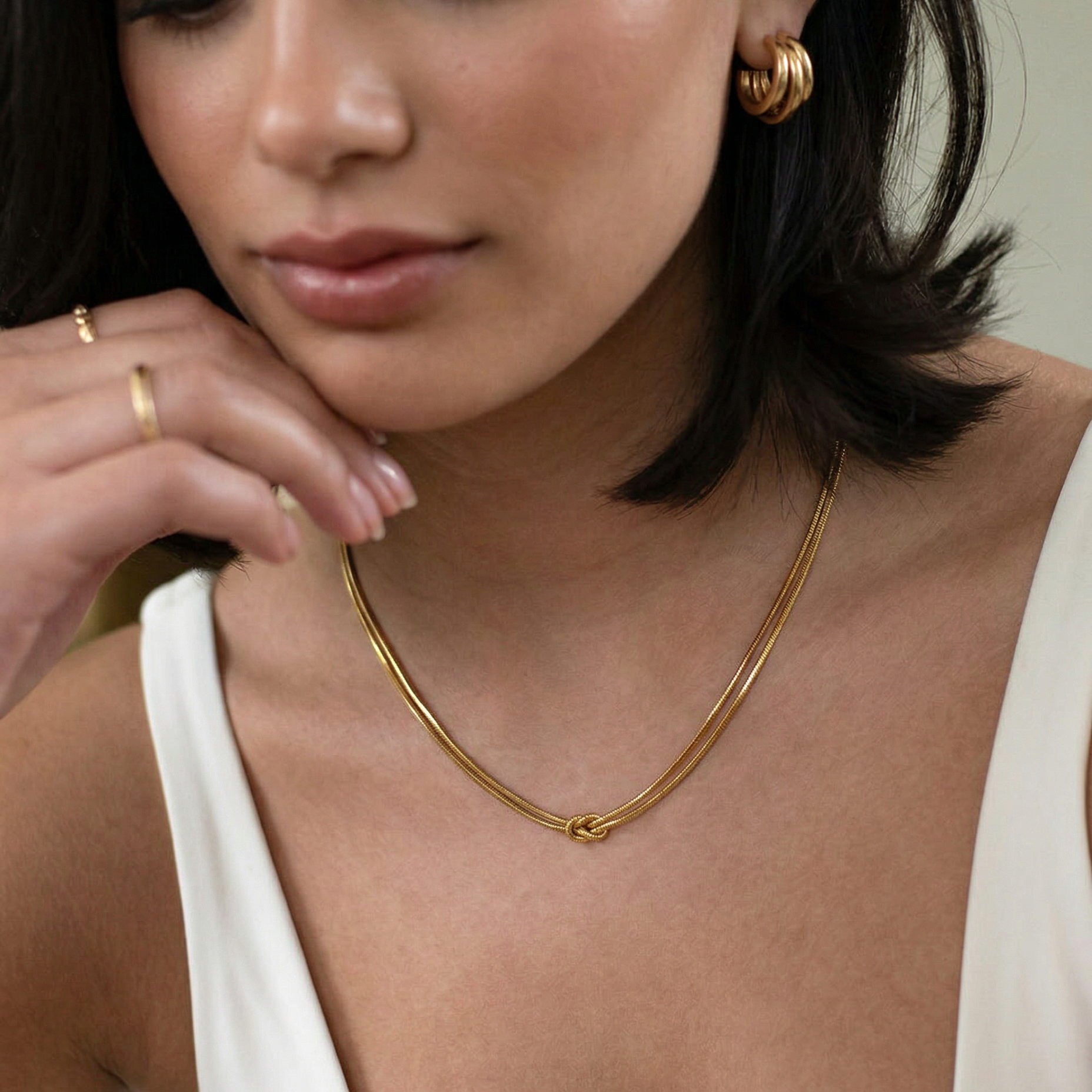 close up photo of a female model wearing a gold-plated choker necklace with a simple infinity symbol design