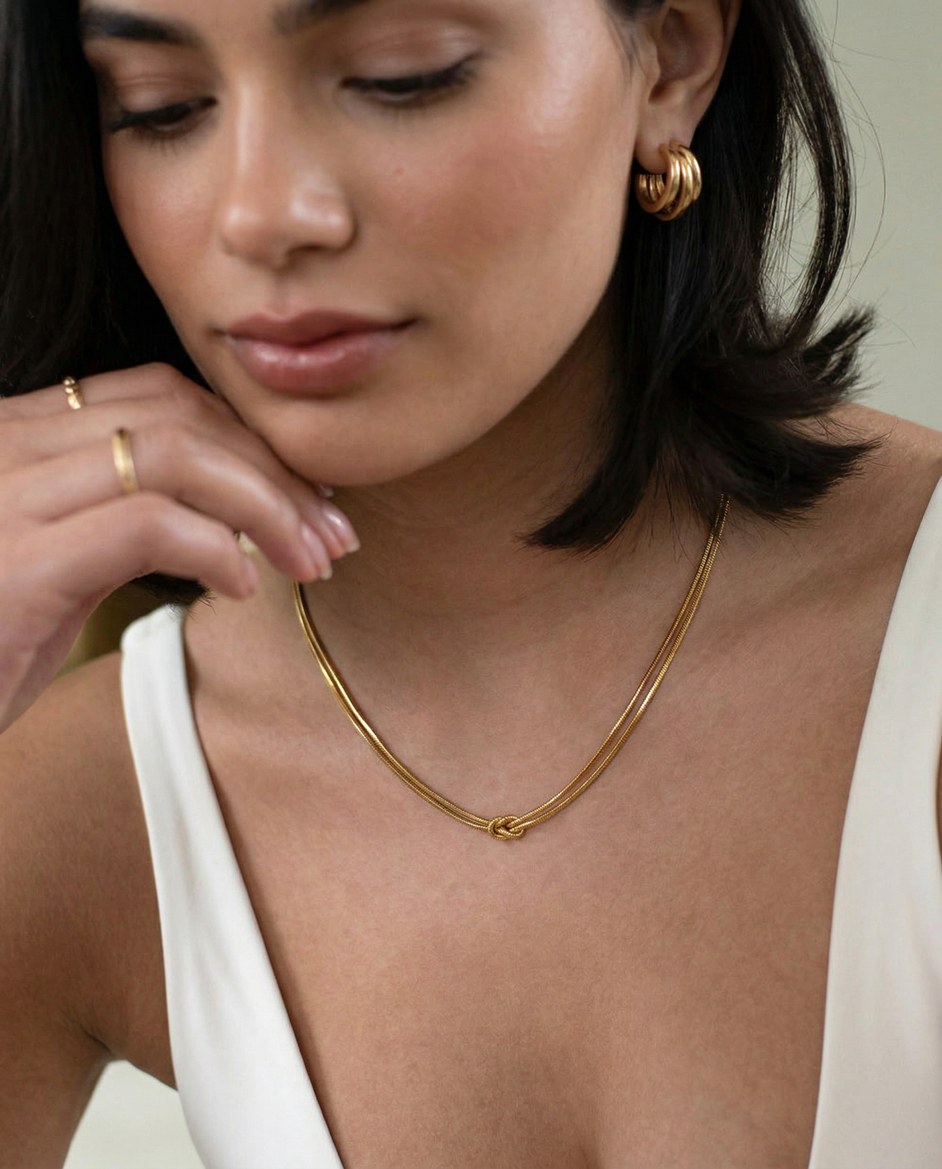 close up photo of a female model wearing a gold-plated choker necklace with a simple infinity symbol design