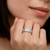 Close-up of a hand wearing A silver ring with a rectangular accent paved with sparkling cubic zirconia stones
