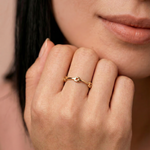 model wearing a gold-colored ring with geometric cutouts, crafted from gold-plated metal, displayed against a white background.