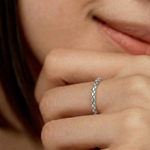 model wearing a sterling silver ring with an intricate scale-like pattern