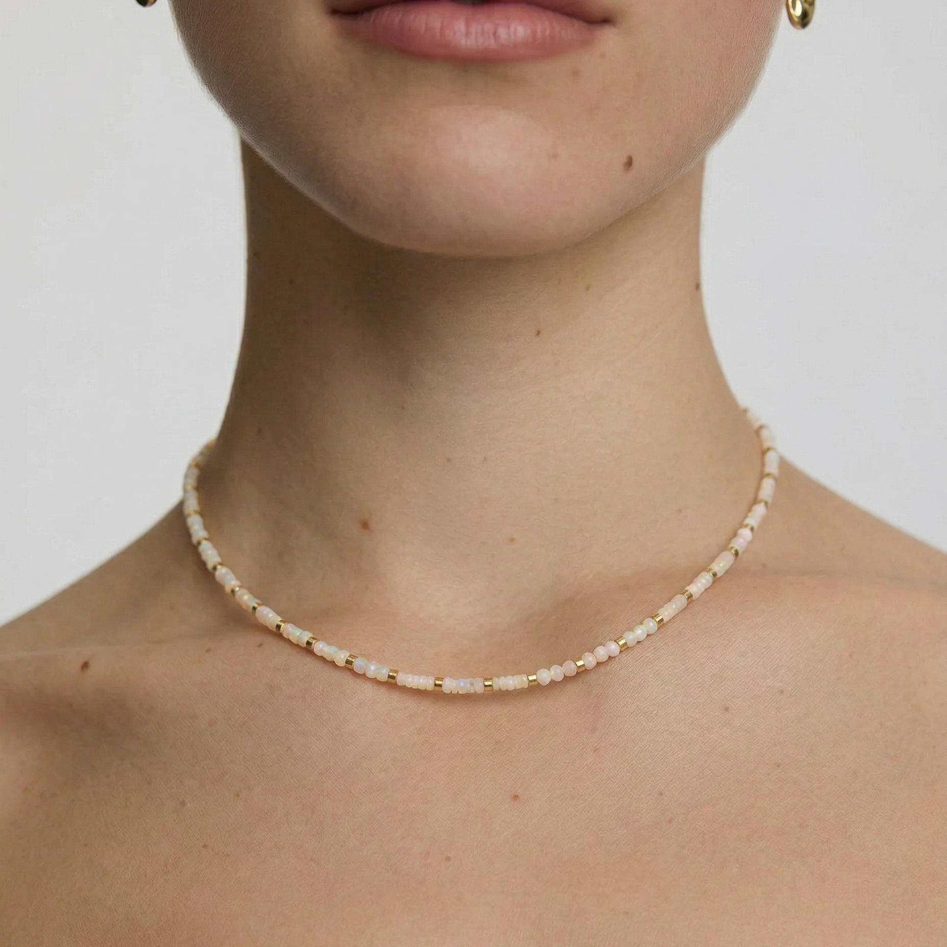 Close-up of a person wearing a delicate white beaded choker