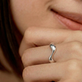 close up of a female model wearing a sleek silver ring with an undulating design, crafted from sterling silver
