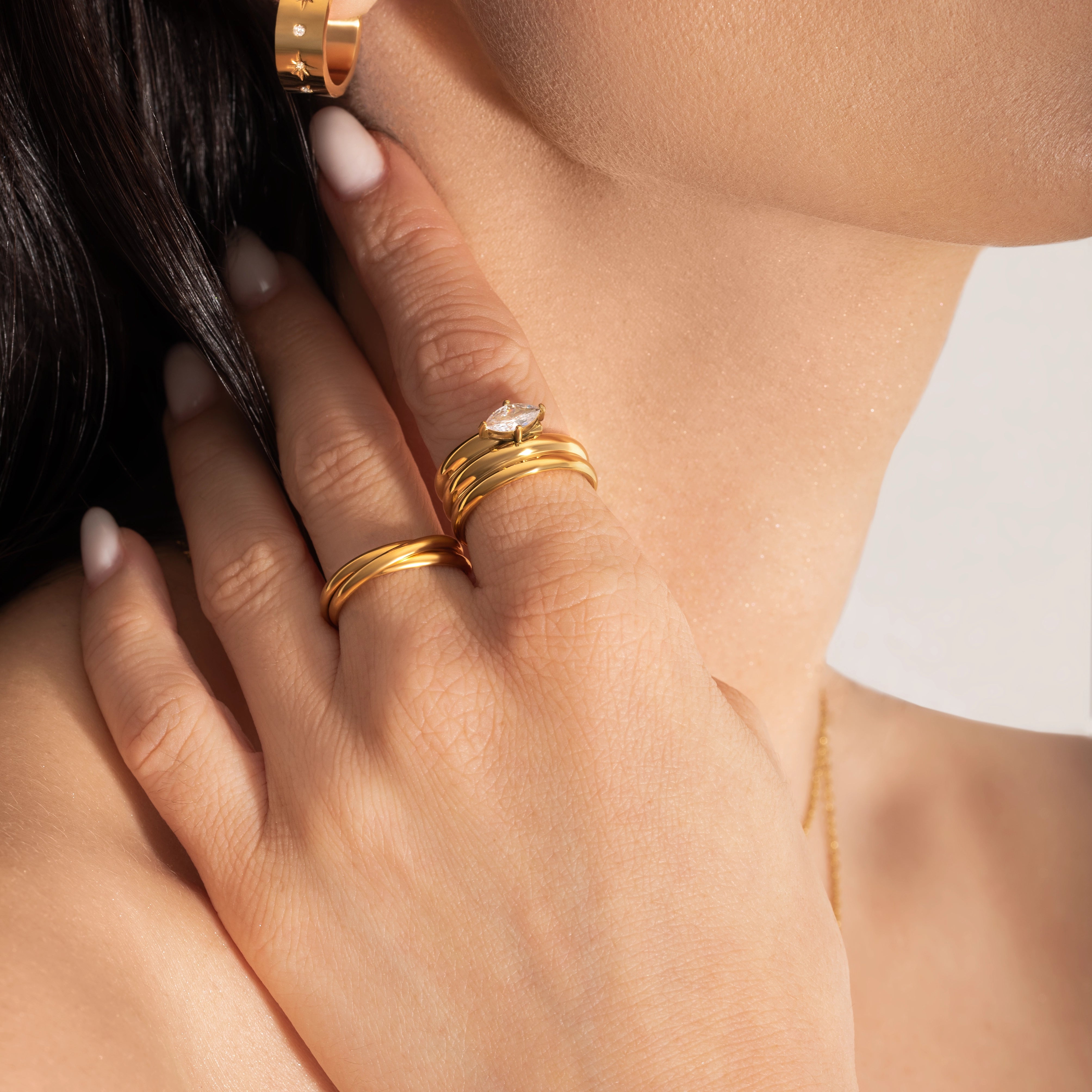 close up of a female model wearing bold statement gold plated ring with big zirconia stone and earrings