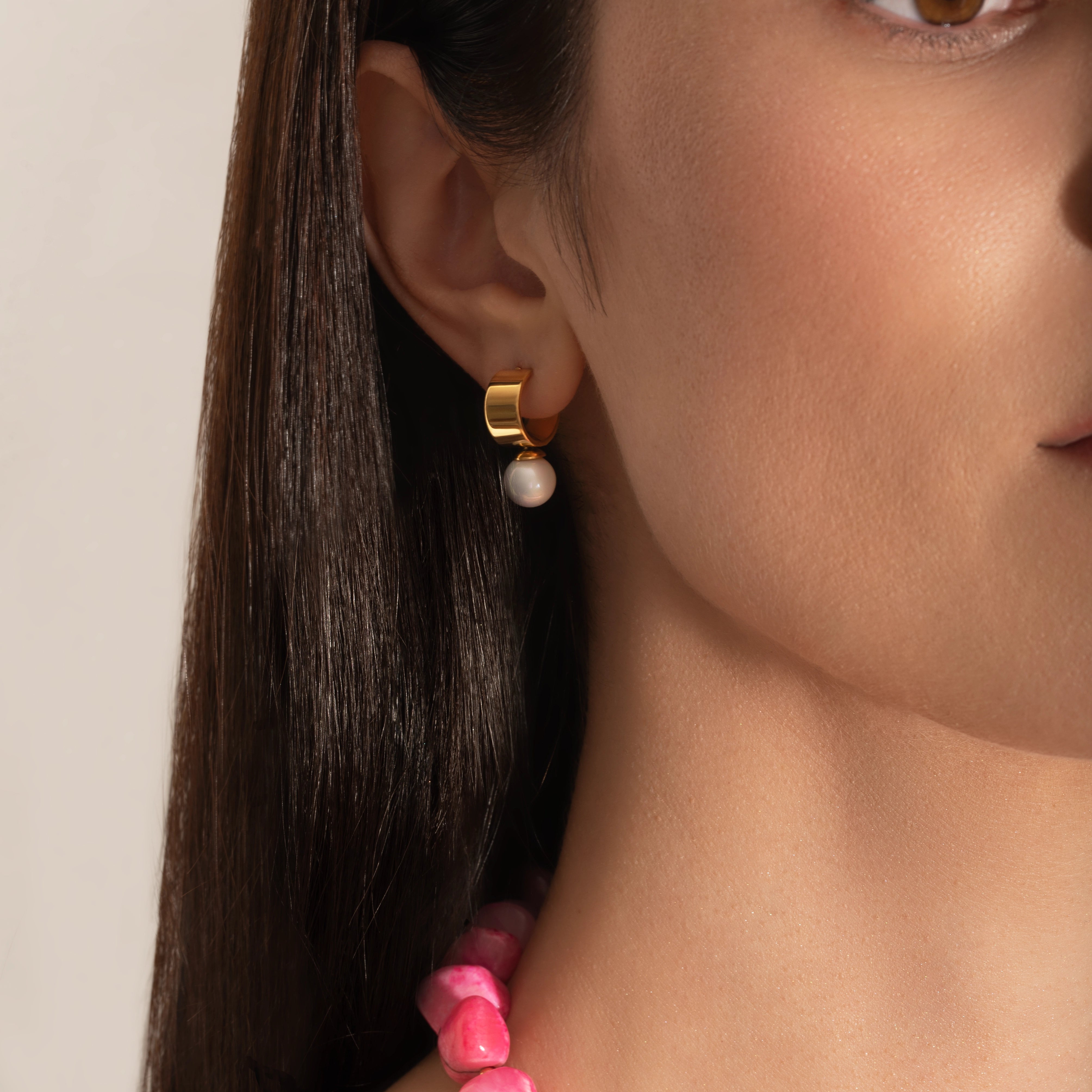 model wearing a pink coral nuggets necklace with metallic beads and a gold heart charm