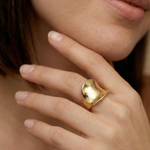 Close-up of a hand wearing a statement gold ring
