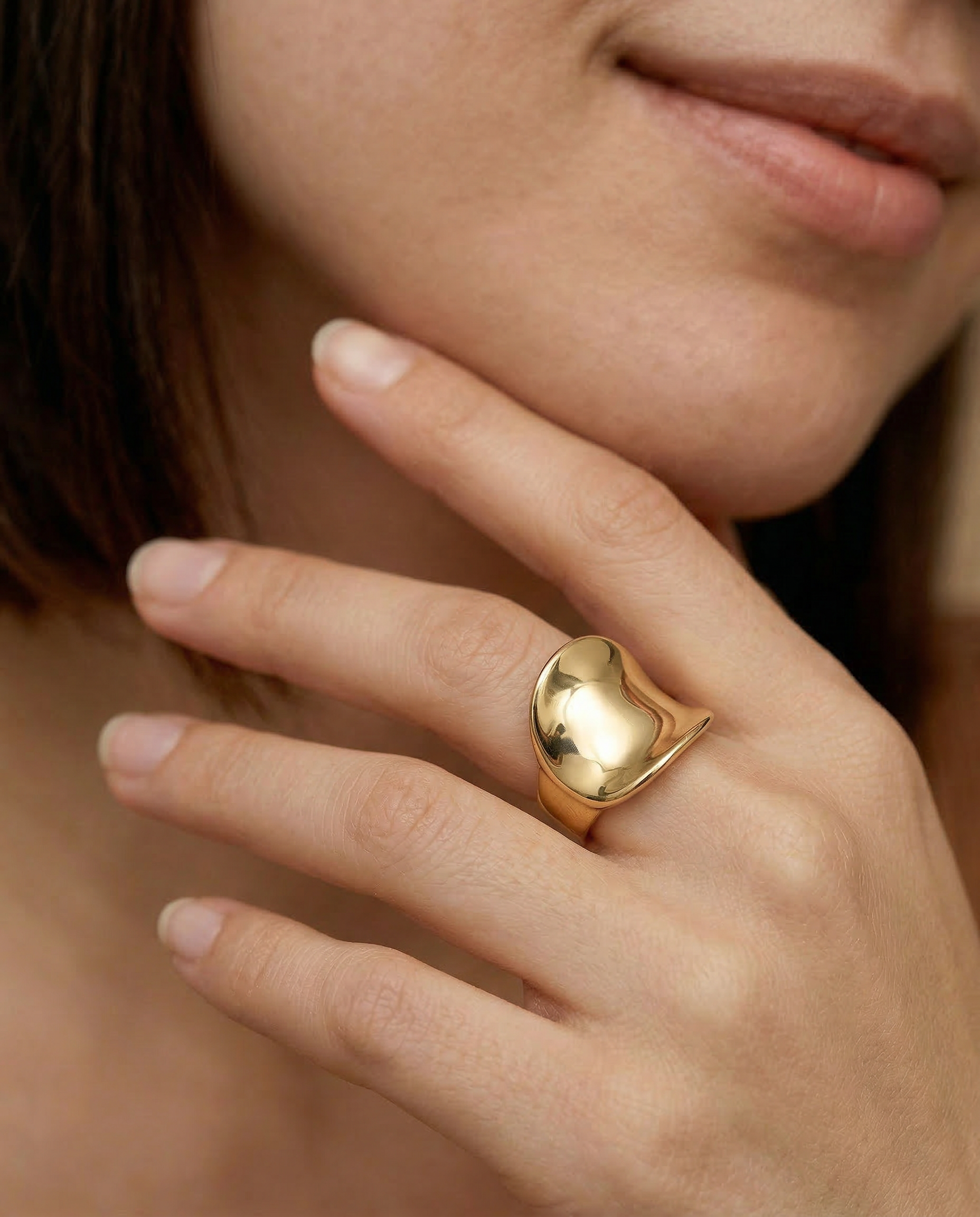 Close-up of a hand wearing a statement gold ring