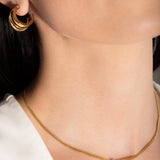 model wearing a gold-plated choker necklace with a simple infinity symbol design