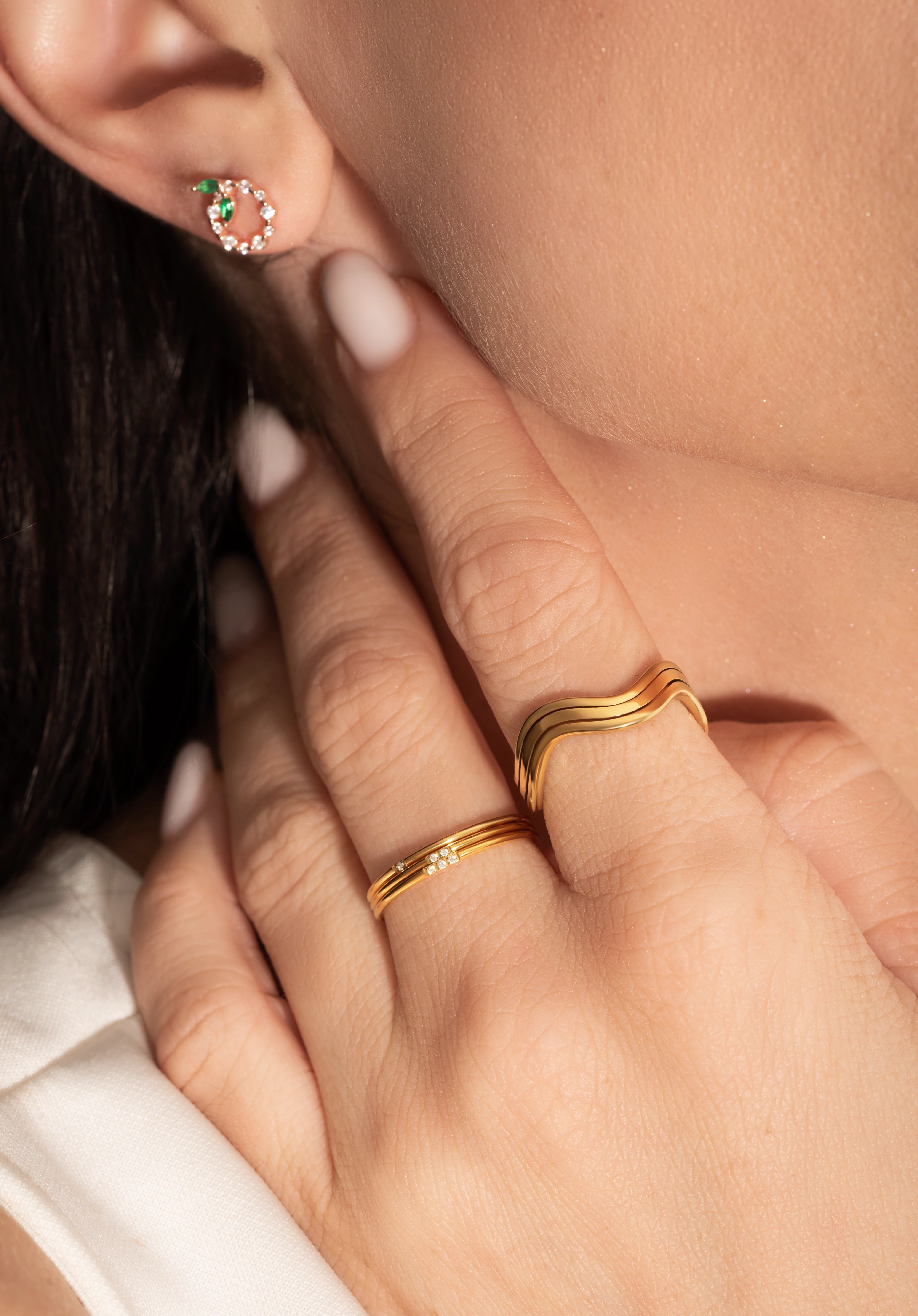close shot of a model wearing 2 delicate gold rings