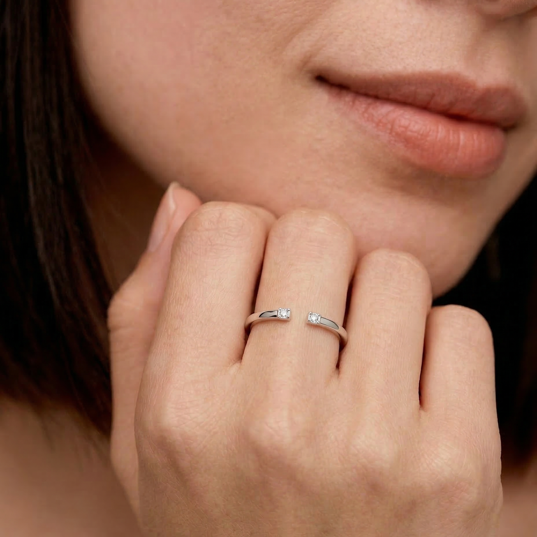 close-up of a model wearing a sterling silver open cuff ring with two tiny CZ stones at each end, by kaleya studio