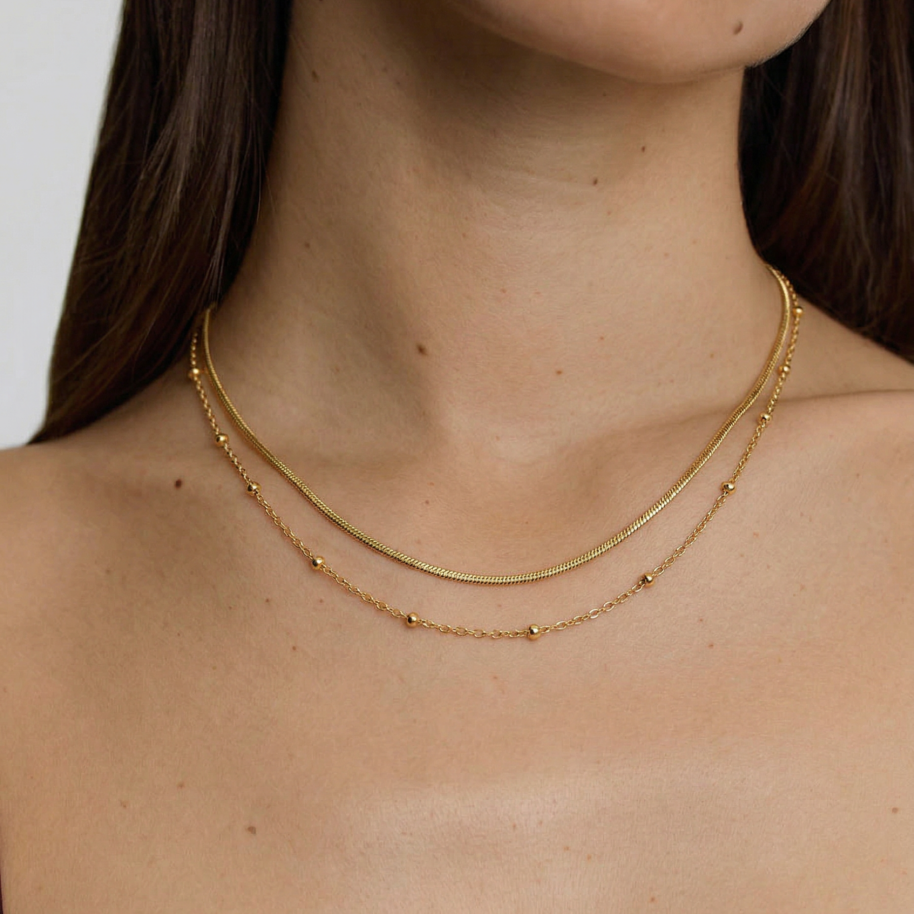 model wearing a delicate layered gold plated necklace