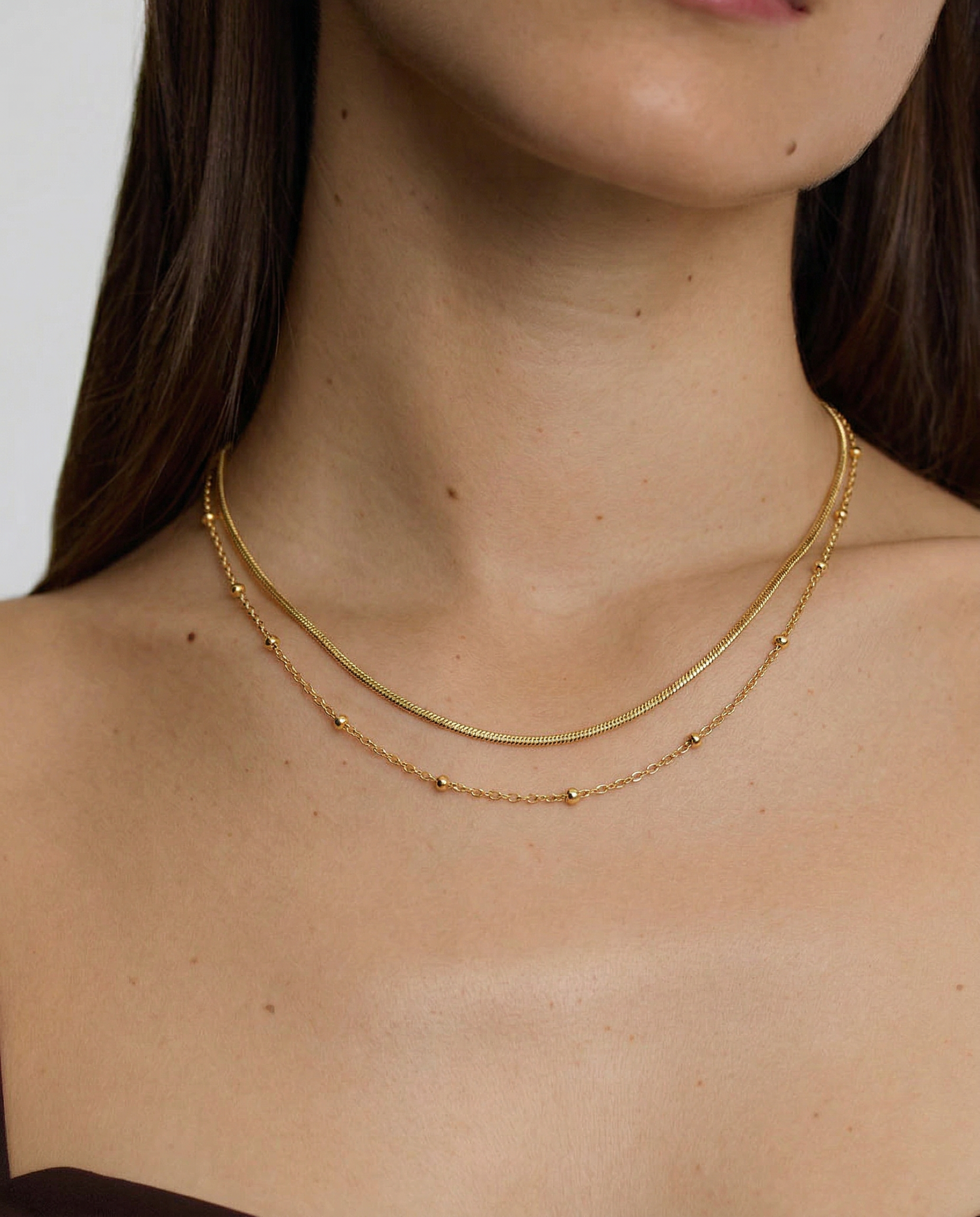 model wearing a delicate layered gold plated necklace
