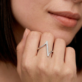Close-up of a woman's hand wearing a sterling silver ring with a lightning bolt design adorned with cubic zirconia stones