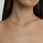 model wearing a delicate pearl necklace with gold plated accents