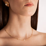 model wearing a gold-plated curb chain necklace with rectangular stations and a single pearl accent
