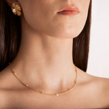 model wearing a gold-plated curb chain necklace with rectangular stations and a single pearl accent