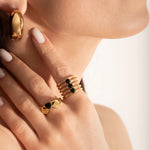 female model wearing 2 gold-plated Claddagh ring with a heart-shaped black gemstone, featuring two hands holding a heart and a crown on top.
