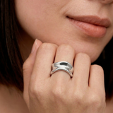 model wearing a sterling silver, asymmetrical, open-ended ring with a smooth, polished surface.