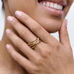 Close-up of a hand wearing a gold ring with a blurred background