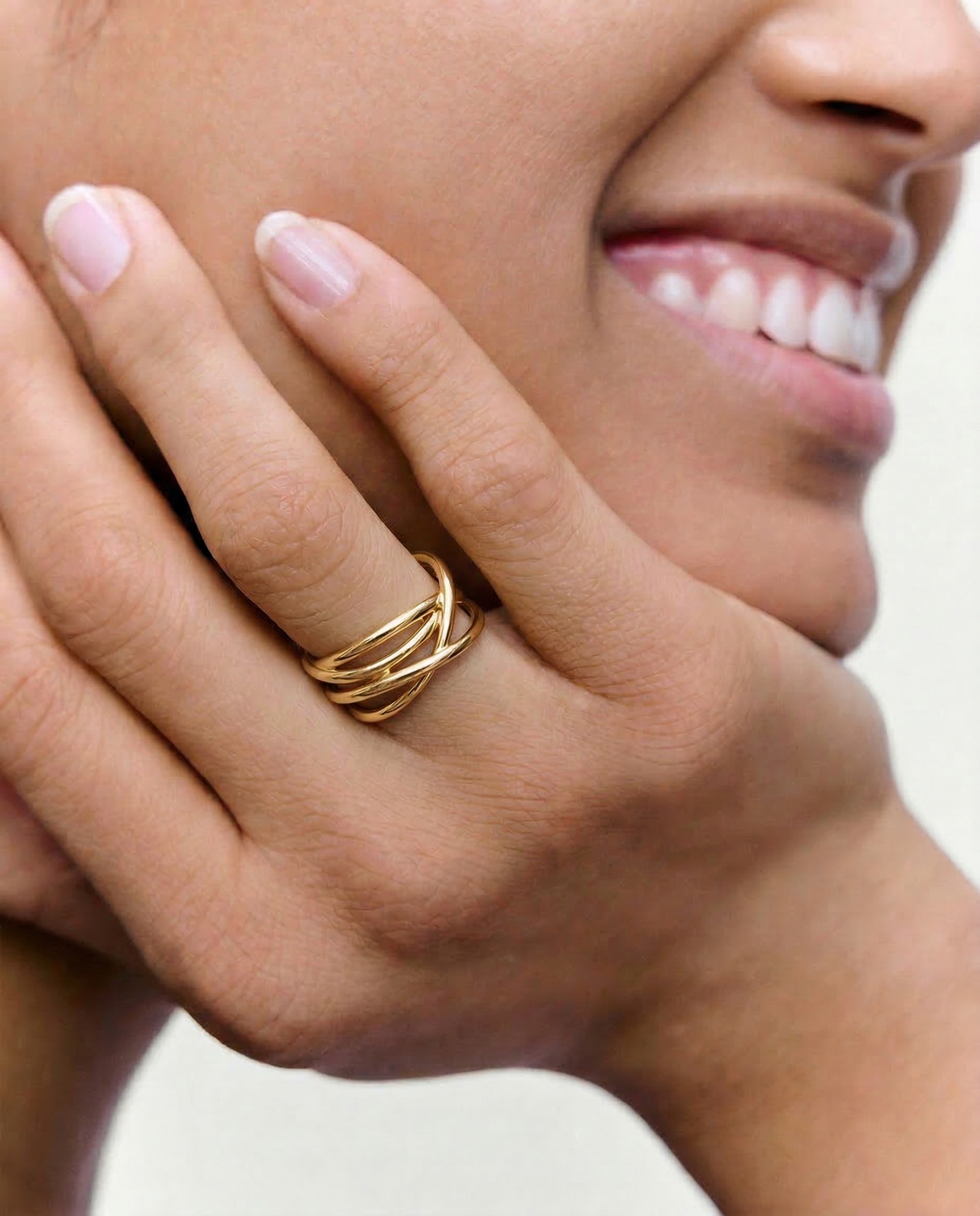 Close-up of a hand wearing a gold ring with a blurred background