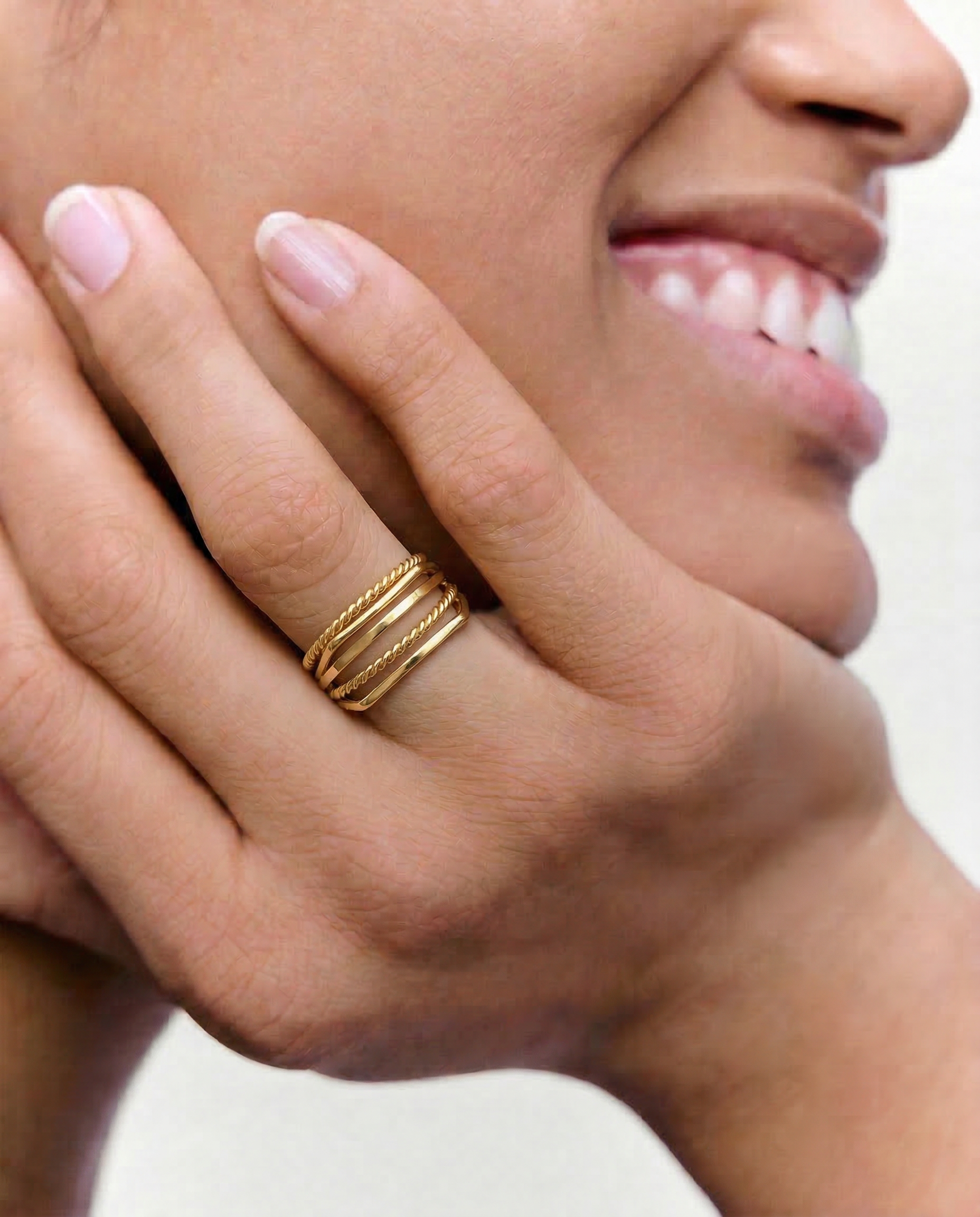 model wearing 5  gold-plated stainless steel stacking rings with a twisted design, polished finish