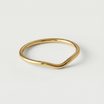 A gold-plated metal ring with a fluid, asymmetrical wave design