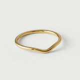 A gold-plated metal ring with a fluid, asymmetrical wave design