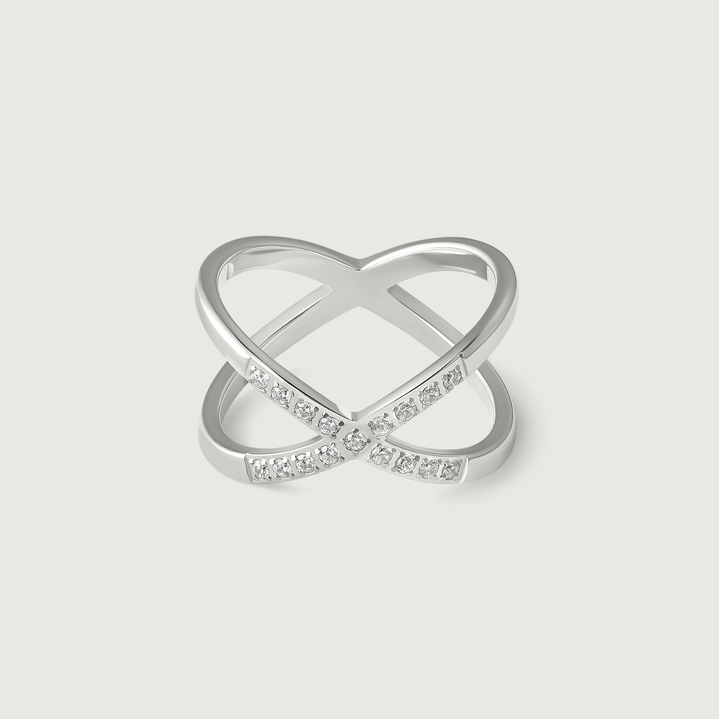 A silver-colored ring with an X-shaped design and sparkling cubic zirconia stones on the intersections.