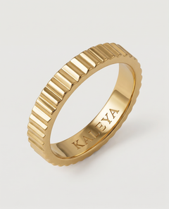 A gold-plated band ring with fluted edges, displayed against a white background