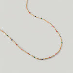 video of a gold-plated necklace with multicolored beads in red, pink, blue, and green, arranged in a alternating pattern between golden bars.