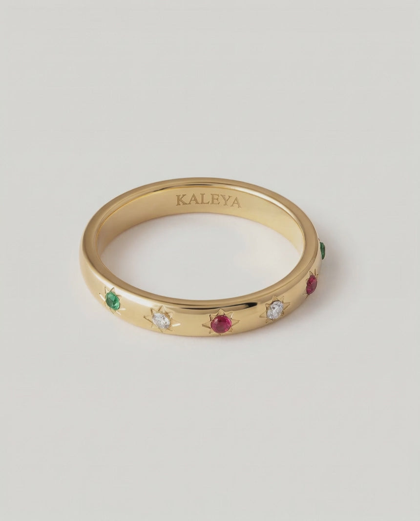rotating video of a gold-plated ring with a series of vibrant gemstones set in star-shaped bezels along the polished band