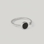 rotating vidoe of a silver ring with a twisted band and a central black onyx stone, with a small silver bead on one end.