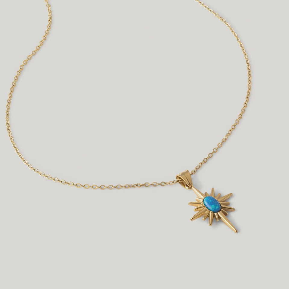 video of a gold-plated necklace with a starburst pendant featuring a blue opal in the center