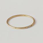 rotating video A gold-plated ring with a polished surface and a trio of brilliant cut cubic zirconia stones on one side