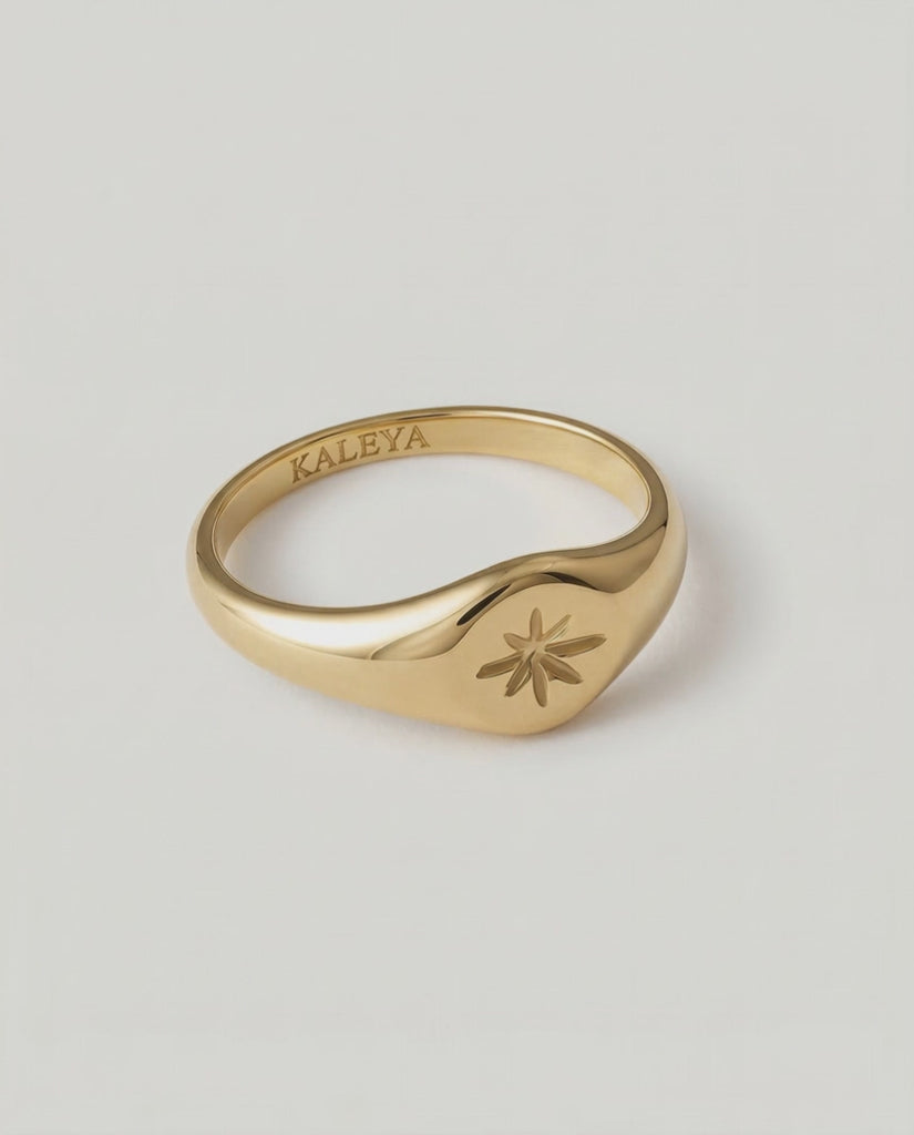 a video showing a gold signet ring with a star engraving on the top, crafted from gold-plated metal.